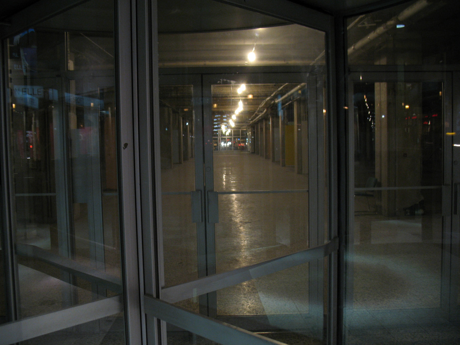 An old empty arcade hallway through glass doors.